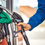 UK driver confused at fuel station pump deciding between petrol and diesel.