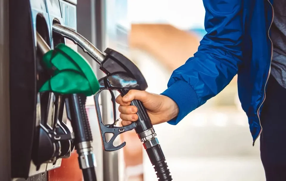 UK driver confused at fuel station pump deciding between petrol and diesel.