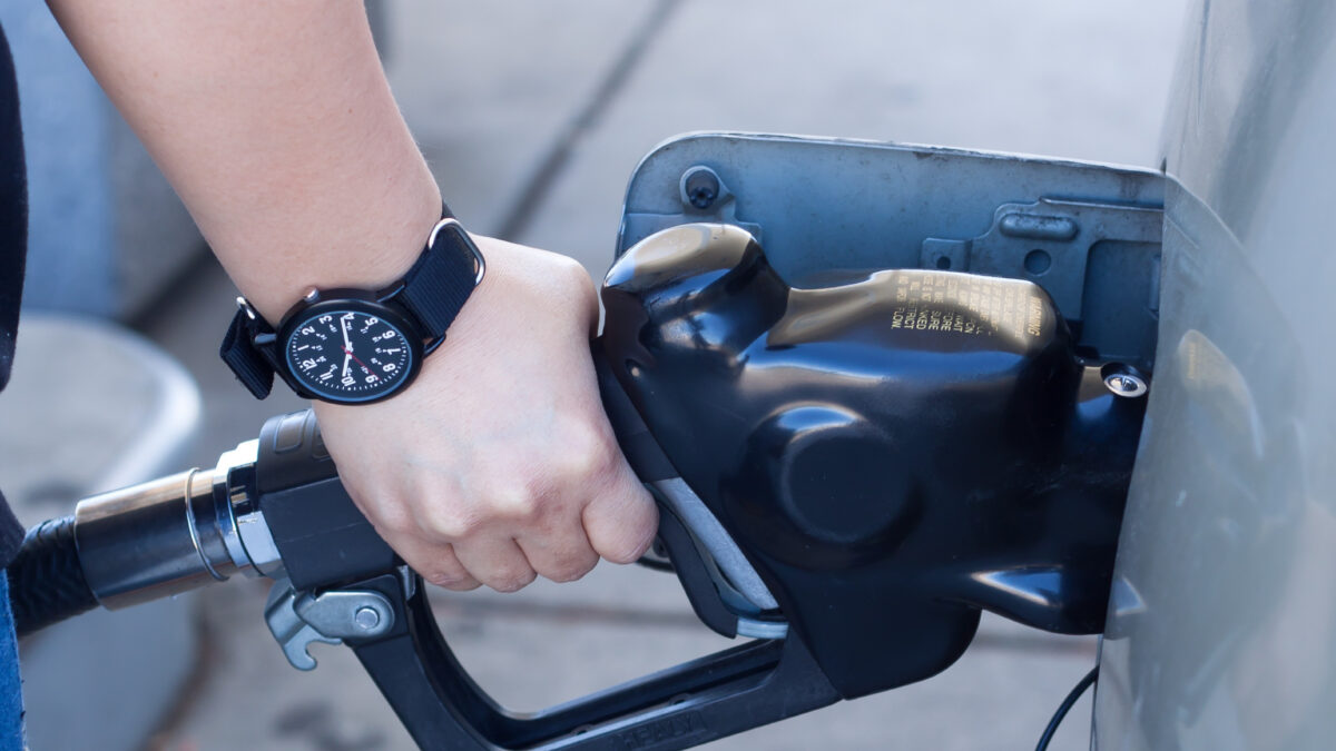 Busy West London fuel station with cars refuelling under bright lights.