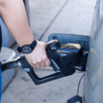 Busy West London fuel station with cars refuelling under bright lights.