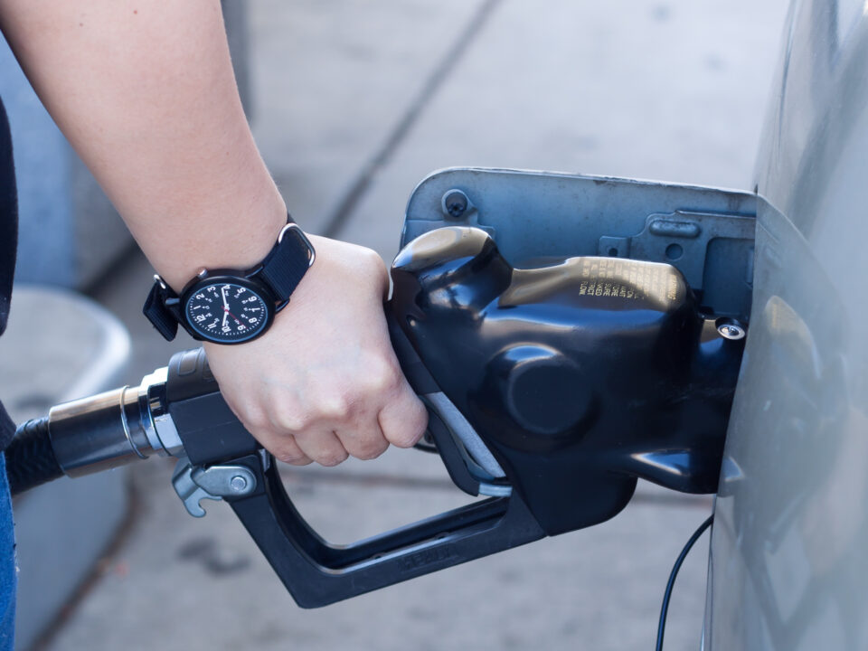 Busy West London fuel station with cars refuelling under bright lights.