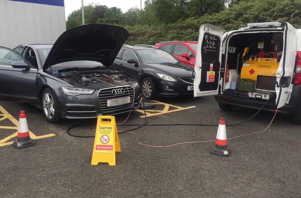 Busy UK motorway service station with cars refuelling.