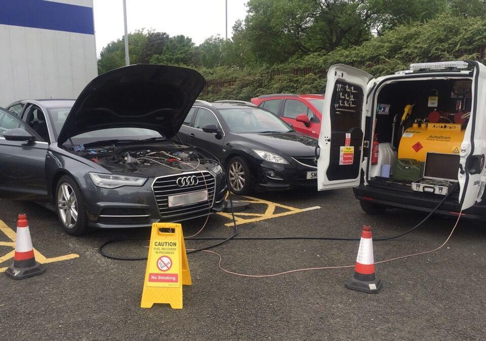 Busy UK motorway service station with cars refuelling.