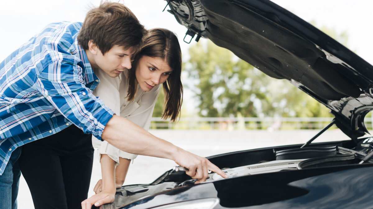 Mechanic draining wrong fuel from a car in South East England service area.