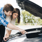 Mechanic draining wrong fuel from a car in South East England service area.