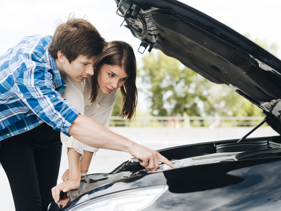 Mechanic draining wrong fuel from a car in South East England service area.