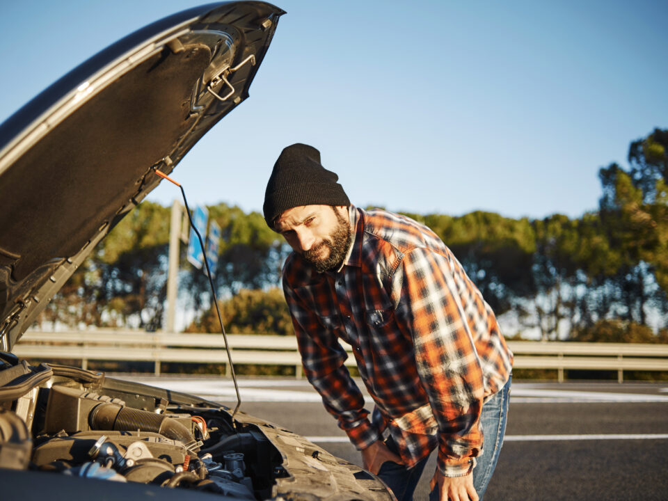 river at a Kensington petrol station carefully checking fuel nozzle before refuelling.